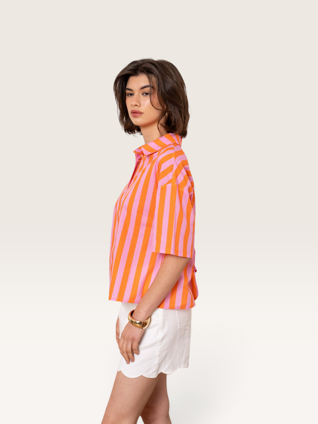 Modèle portant une chemise rayée rose et orange 100% coton de la marque Sable_blanc_collection