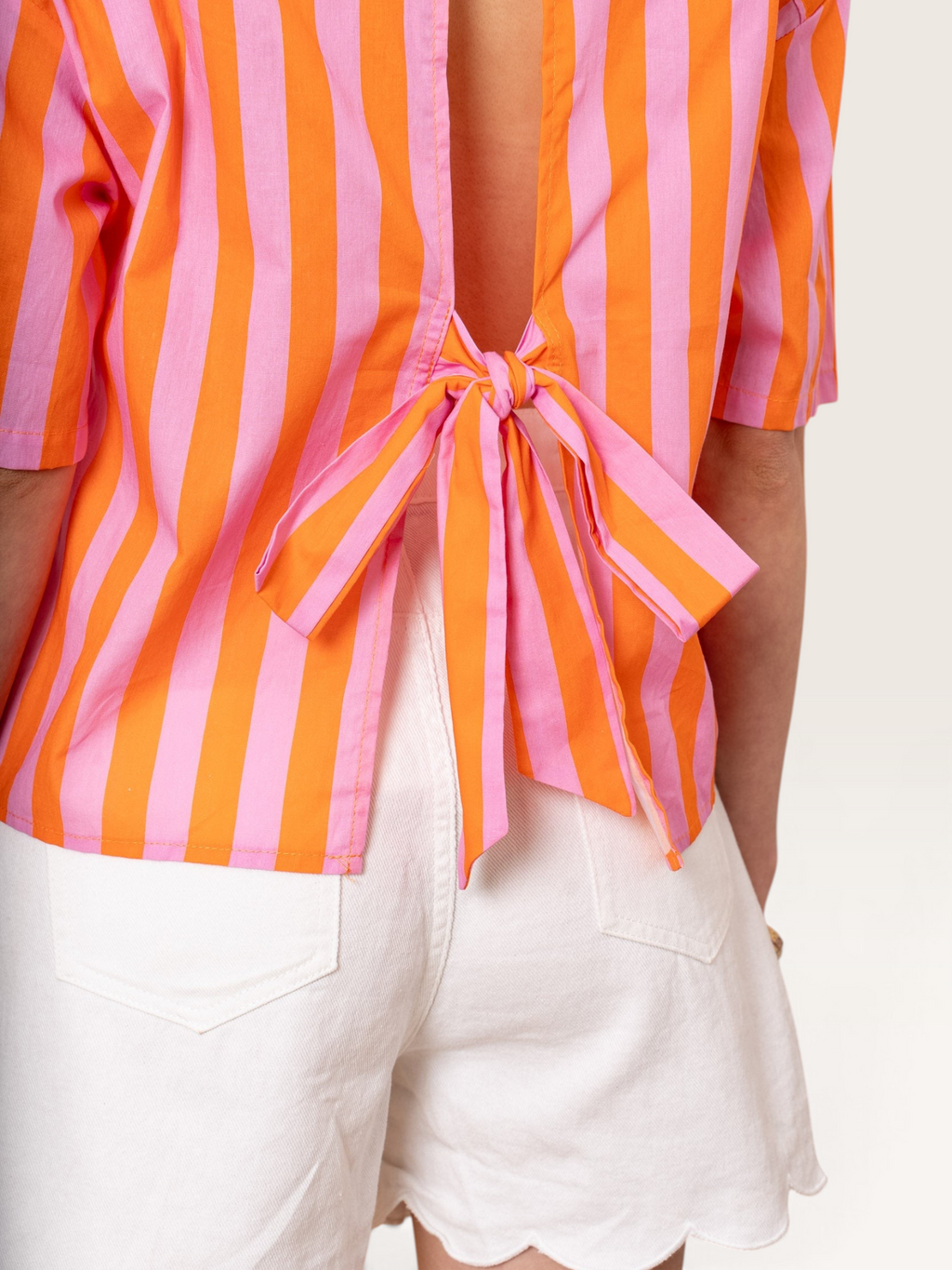 Chemise Sable_blanc_collection en coton rayé orange et rose avec un nœud décoratif ouvert dans le dos