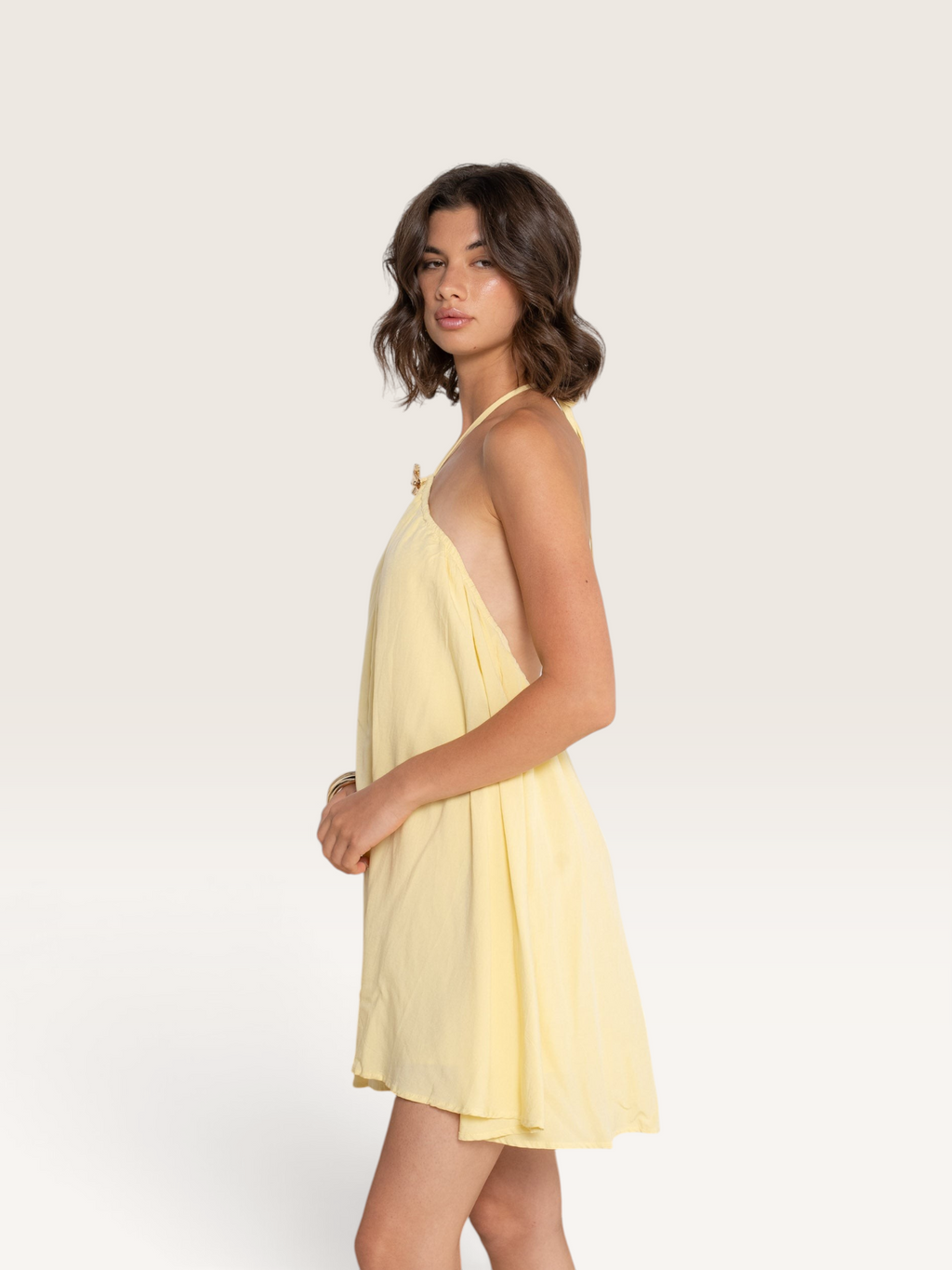 Modèle portant le haut jaune Sable_blanc_collection Kilky à dos nu avec détails dorés sur les bretelles