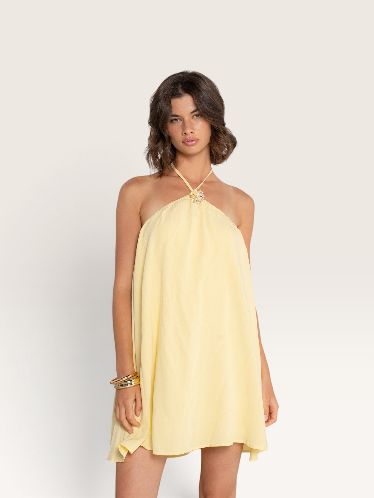 Modèle portant le haut jaune Sable_blanc_collection Kilky avec encolure dos nu et détail floral décoratif
