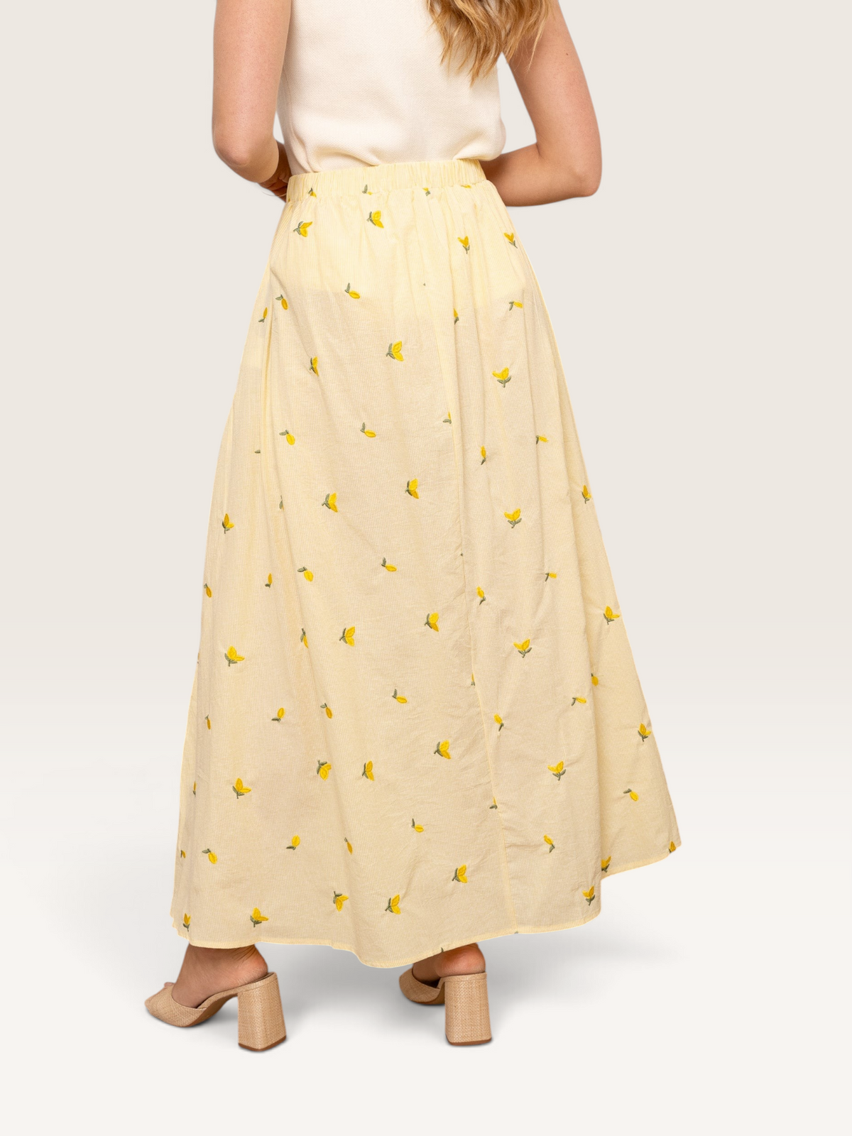 Jupe longue Sable_blanc_collection en coton jaune avec motif citrons, vue de dos portée avec un haut blanc