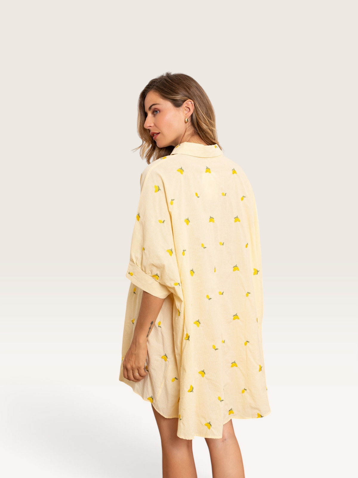 Femme portant une robe chemise Sable_blanc_collection jaune à motif citrons, coupe ample et décontractée