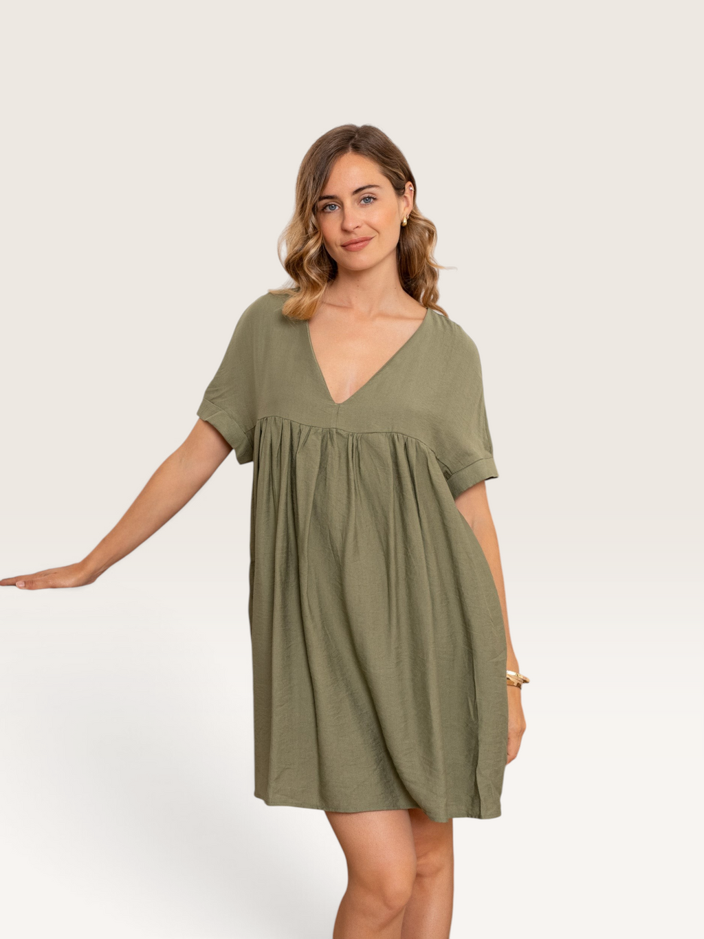 Robe courte Kilky en coton vert kaki Sable_blanc_collection portée par une femme avec un col en V