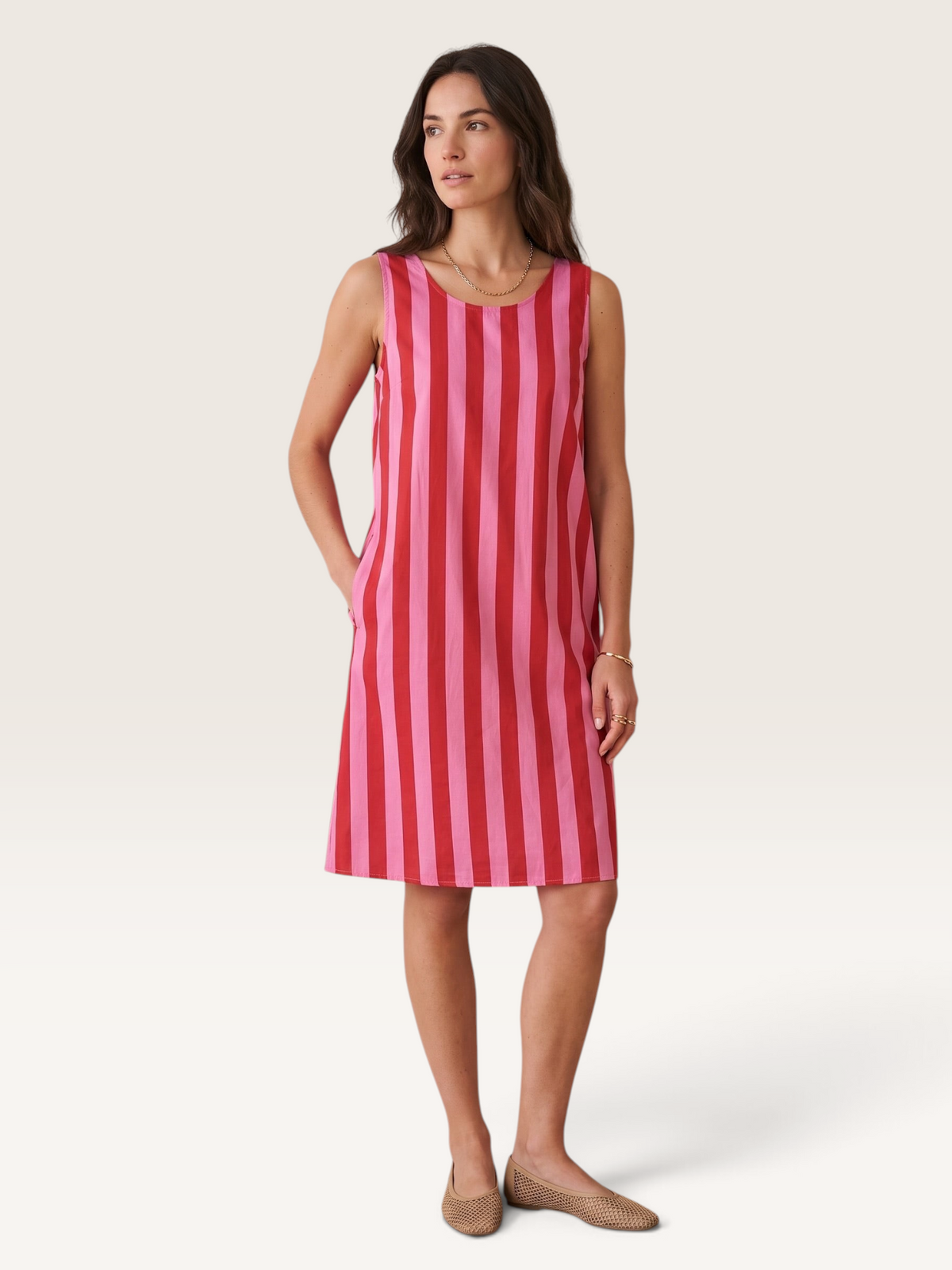 Robe courte rayée rose et rouge Sable_blanc_collection en coton sans manches avec poches portee par un mannequin