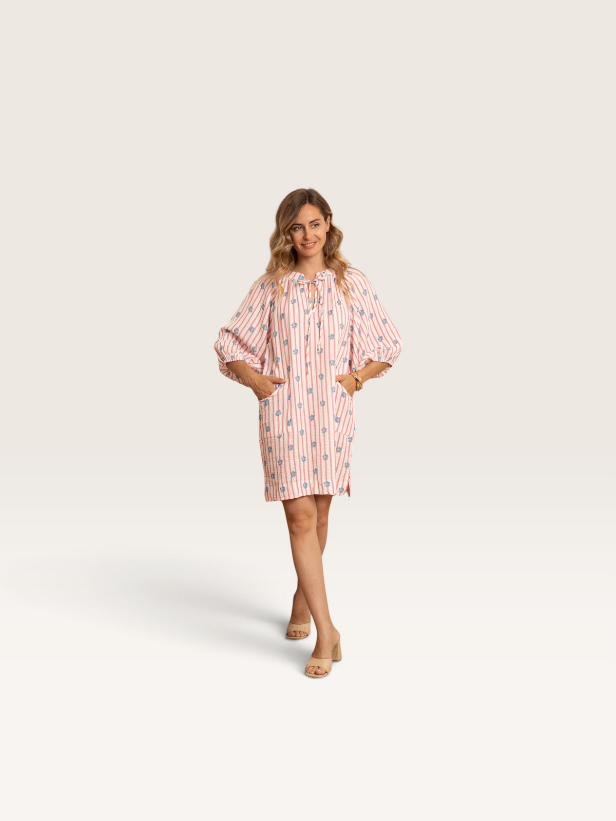 Femme portant la robe Kilky Sable_blanc_collection à rayures roses et motifs floraux bleus avec manches bouffantes