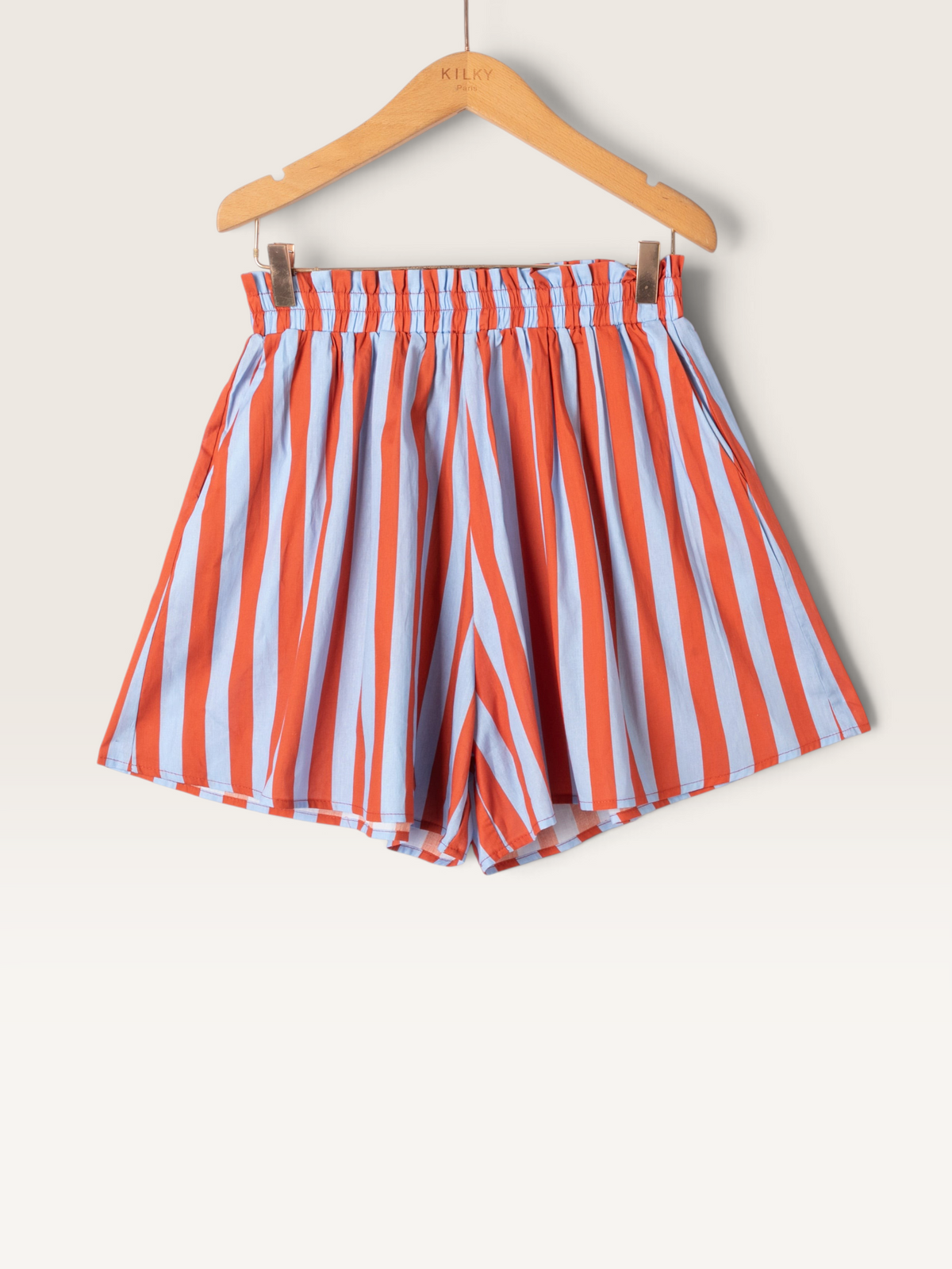 Short rayé Sable_blanc_collection en coton orange et bleu clair avec taille élastiquée sur cintre en bois